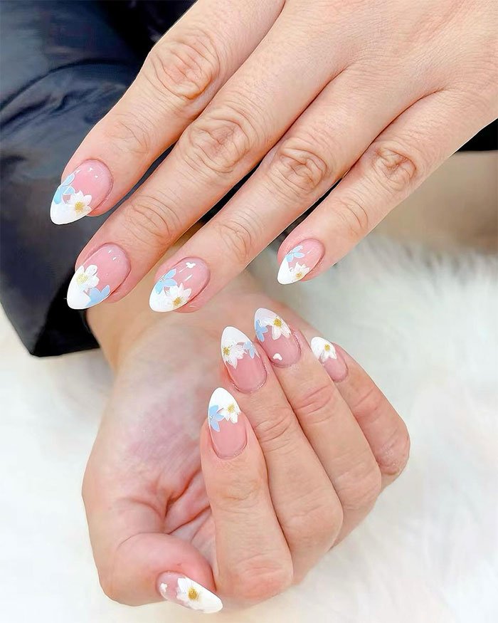 The nail shape is an almond shape using sheer glossy pink color. However, the nail tip incorporates a modified French style with DELICATE DAISY floral patterns.